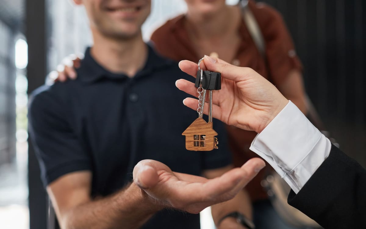 Buyer receiving house keys from an AMG RLTY Solutions agent in Fort Wayne